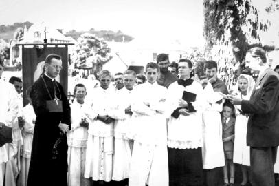 A imagem acima, pertencente ao acervo da professora aposentada Nuely Communello (a menina de véu, à direita, com 10 anos), traz o registro da visita do arcebispo Dom Vicente Scherer (à esquerda) ao distrito, em 1947. Aparecem ainda o escrivão distrital Afonso Pires, lendo o discurso, à direita), Antonio Damin, João Vitório Cavalli e, ao centro, com os braços cruzadas, o seminarista Leduvino Benedito Lazzarotto, ordenado padre em Santa Lúcia em 1962.  