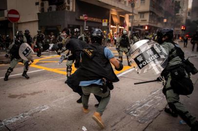 Police try to stop a protester on a road in the Wanchai area in Hong Kong on October 1, 2019, as the city observes the National Day holiday to mark the 70th anniversary of communist Chinas founding. - Police fanned out across Hong Kong on October 1 in a bid to deter pro-democracy protests as the city marked communist Chinas 70th birthday, with local officials attending a closed door flag-raising ceremony behind closed doors. (Photo by NICOLAS ASFOURI / AFP)