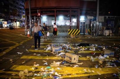  People cross a road covered in debris after violent demonstrations took place in the streets of Hong Kong on October 1, 2019, as the city observes the National Day holiday to mark the 70th anniversary of communist Chinas founding. - Police fanned out across Hong Kong on October 1 in a bid to deter pro-democracy protests as the city marked communist Chinas 70th birthday, with local officials attending a closed door flag-raising ceremony behind closed doors. (Photo by ANTHONY WALLACE / AFP)Editoria: POLLocal: Hong KongIndexador: ANTHONY WALLACESecao: governmentFonte: AFPFotógrafo: STF