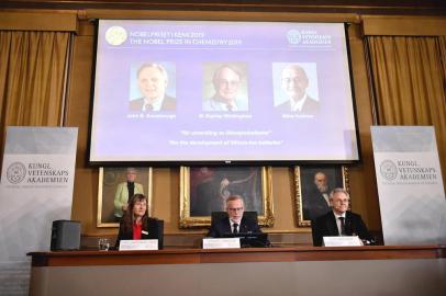  Goran K Hansson (C), Secretary General of the Royal Swedish Academy of Sciences, and academy members Sara Snogerup Linse (L) and Olof Ramstrom, announce the winners  of the 2019 Nobel Prize in Chemistry (Up L-R) John Goodenough of US, Britains Stanley Whittingham and Japans Akira Yoshino during a news conference at the Royal Swedish Academy of Sciences in Stockholm, Sweden, on October 9, 2019. - John Goodenough of US, Britains Stanley Whittingham and Japans Akira Yoshino won the 2019 Nobel Chemistry Prize for the development of lithium-ion batteries, the Royal Swedish Academy of Sciences said.This lightweight, rechargeable and powerful battery is now used in everything from mobile phones to laptops and electric vehicles...(and) can also store significant amounts of energy from solar and wind power, making possible a fossil fuel-free society, the jury said. (Photo by Naina Helen JAMA / TT News Agency / AFP) / Sweden OUTEditoria: HUMLocal: StockholmIndexador: NAINA HELEN JAMASecao: chemistryFonte: TT News AgencyFotógrafo: STR