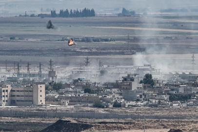 This picture taken on October 13, 2019 from the Turkish city of Ceylanpinar shows smoke rising and explosions in the Syrian border town of Ras al-Ain as fighting rages along the border on the fifth day of a Turkish offensive in Syria against the Kurdish Peoples Protection Units (YPG) that has provoked an international outcry and left dozens of civilians and fighters dead. - The Syrian Observatory for Human Rights said the capture of Tal Abyad today left the town of Ras al-Ain as the only other major target remaining in the initial phase of the five-day-old Turkish assault. (Photo by Ozan KOSE / AFP)