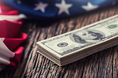 American dollars an Usa Flag.Close up of american flag and dollar cash money on old  oak woodAmerican dollars an Usa Flag.Close up of american flag and dollar cash money on old  oak wood.Fonte: 136089979