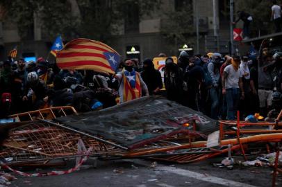 A protester waves a Catalan pro-independence estelada flag during clashes with police near the Police headquarters in Barcelona, on October 18, 2019, on the day that separatists have called a general strike and a mass rally. - Spains protest-hit northeast was gripped by a general strike today as thousands of freedom marchers converged on Barcelona for a mass show of dissent over the jailing of nine Catalan separatist leaders. (Photo by Pau Barrena / AFP)
