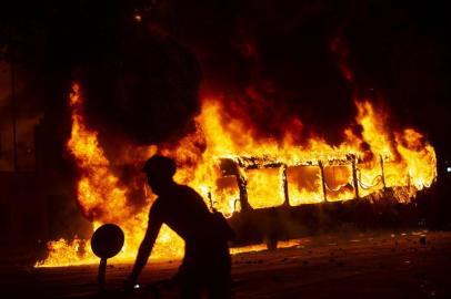 Protestos no metrô de Santiago, no Chile, acaba com incêndioA bus burns down in downtown Santiago, on October 18, 2019, following a mass fare-dodging protest. - School and university students joined a mass fare-dodging protest in Santiagos metro following the highest fare rise in recent years, paralysing two of its main lines. (Photo by CLAUDIO REYES / AFP)