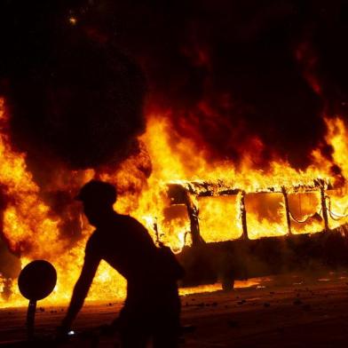 Protestos no metrô de Santiago, no Chile, acaba com incêndioA bus burns down in downtown Santiago, on October 18, 2019, following a mass fare-dodging protest. - School and university students joined a mass fare-dodging protest in Santiagos metro following the highest fare rise in recent years, paralysing two of its main lines. (Photo by CLAUDIO REYES / AFP)