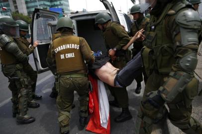 The police arrest a demonstrator during clashes between protesters and the police at Plaza de Maipu in Santiago, on October 19, 2019. - Chiles president declared a state of emergency in Santiago Friday night and gave the military responsibility for security after a day of violent protests over an increase in the price of metro tickets. (Photo by Pablo VERA / AFP)