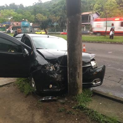 Uma passageira carregava um vidro no banco do carona. O vidro atingiu o braço do condutor, que perdeu o controle do carro.