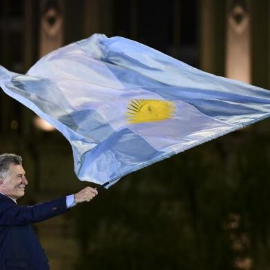 Argentina's President and presidential candidate of the Juntos por el Cambio party Mauricio Macri waves a national flag during the closing rally of his campaign in Cordoba, Argentina, on October 24, 2019. - Argentina holds presidential elections on October 27. (Photo by Ronaldo SCHEMIDT / AFP)