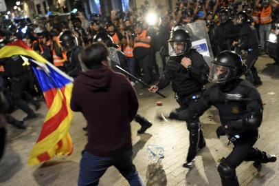 A polícia colide com manifestantes pró-independência durante uma manifestação convocada pelos Comitês de Defesa da República (CDR), fora da sede da polícia espanhola em Barcelona.