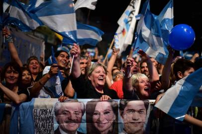 Supporters of Argentinas presidential candidate for the Frente de Todos party Alberto Fernandez celebrate outside of the party headquarters in Buenos Aires on October 27, 2019. - Peronist candidate Alberto Fernandez won Argentinas presidential election in the first round on Sunday, official results showed, bringing to an end the crisis-plagued rule of market-friendly incumbent Mauricio Macri. (Photo by RONALDO SCHEMIDT / AFP)