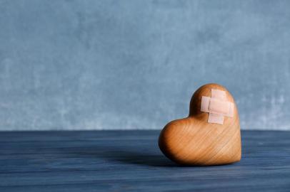  PORTO ALEGRE, RS, BRASIL, 28/10/2019- Coração de madeira com emplastros adesivos na mesa. (Foto: New Africa / stock.adobe.com)Fonte: 238291213