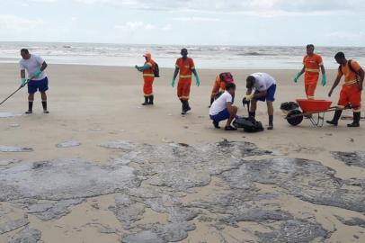 Manchas de óleo na praia da Avenida Soares Lopes, em Ilhéus, na Bahia, são limpas por equipes da Marinha do Brasil e voluntários.