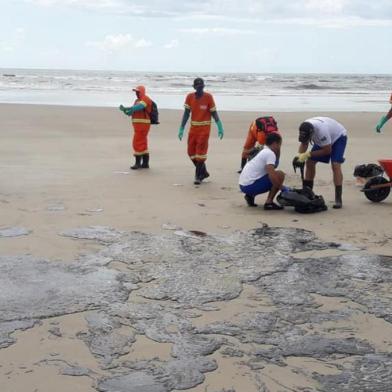 Manchas de óleo na praia da Avenida Soares Lopes, em Ilhéus, na Bahia, são limpas por equipes da Marinha do Brasil e voluntários.