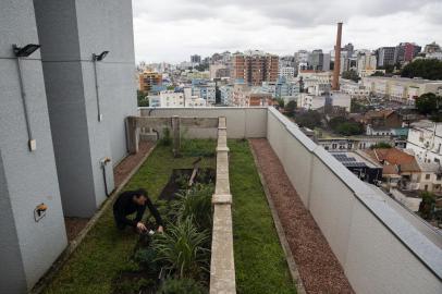 PORTO ALEGRE, RS, BRASIL, 22-10-2019: O morador Douglas Flores cuida de horta coletiva no terraço do Edifício Pueblo, na rua Garibaldi, no bairro Floresta. O prédio tem apartamentos privativos com banheiro e outras áreas compartilhadas pelos moradores, como lavanderia, piscina, academia, salão de festas e rooftop. (Foto: Mateus Bruxel / Agência RBS)