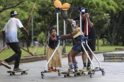  PORTO ALEGRE, RS, BRASIL - 09/11/2019Projeto possibilita que crianças com deficiência andem de skate. Na foto, Mariani de Borba Frank Athaíde dá carona para Laura Mendes da Silva, ambas empurradas pelo Daniel Paniagua