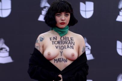 EDITORS NOTE: Graphic content / Chilean singer Mon Laferte, exposes her breast with writings reading In Chile they torture, rape and kill, as she arrives at the 20th Annual Latin Grammy Awards in Las Vegas, Nevada, on November 14, 2019. (Photo by Bridget BENNETT / AFP)