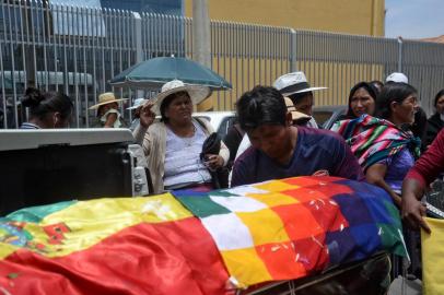 A relative mourns by the coffin -covered with a Bolivian national flag and a Wiphala- of a supporter of Bolivian ex-President Evo Morales killed during clashes with the police in Sacaba, Cochabamba, Bolivia, on November 16, 2019. - The UN rights chief voiced alarm Saturday at the deadly crisis in Bolivia, warning that excessive force by police was an extremely dangerous development. Morales resigned and fled to Mexico after losing the support of Bolivias security forces following weeks of protests over his disputed re-election that has seen 15 people killed and more than 400 wounded. (Photo by STR / AFP)