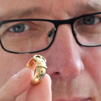 Arthur Brand, also dubbed the Indiana Jones of the Art World, poses with an 18-carat golden ring, which is said to have belonged to Irish playwright Oscar Wilde (1854-1900), at his apartment in Amsterdam on October 30, 2019. - A golden ring once given as a present by the famed Irish writer Oscar Wilde has been recovered by a Dutch art detective nearly 20 years after it was stolen from Britains Oxford University. The friendship ring, a joint gift from Wilde to a fellow student in 1876, was taken during a burglary in 2002 at Magdalen College, where the legendary dandy studied. At the time it was valued at GBP 35,000 (40,650 euros, USD 45,000). The trinkets whereabouts remained a mystery for years and there were fears that the ring -- shaped like a belt and buckle and made from 18-carat gold -- had even been melted down. But Arthur Brand, a Dutchman dubbed the Indiana Jones of the Art World for recovering a series of high-profile stolen artworks, used his underworld connections to finally find it. (Photo by JOHN THYS / AFP)