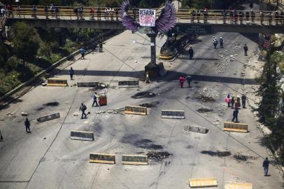 View of the road linking El Alto and La Paz blocked by supporters of the ex-President Evo Morales, as seen from El Alto, Bolivia on November 16, 2019. - Supporters of Bolivian ex-President Evo Morales are blocking roads leading to La Paz, causing shortages of products at markets. The UN rights chief voiced alarm Saturday at the deadly crisis in Bolivia, warning that excessive force by police was an extremely dangerous development and could see the situation could spin out of control. Morales resigned and fled to Mexico after losing the support of Bolivias security forces following weeks of protests over his disputed re-election that has seen 15 people killed and more than 400 wounded. (Photo by RONALDO SCHEMIDT / AFP)