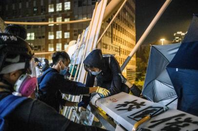  A protester (C) prepares to lower herself down a rope from a bridge to a highway, to escape from Hong Kong Polytechnic University campus and from police, in Hung Hom district in Hong Kong on November 18, 2019. - Dozens of Hong Kong protesters escaped a two-day police siege at a campus late November 18 by shimmying down a rope from a bridge to awaiting motorbikes in a dramatic and perilous breakout that followed a renewed warning by Beijing of a possible intervention to end the crisis engulfing the city. (Photo by ANTHONY WALLACE / AFP)Editoria: WARLocal: Hong KongIndexador: ANTHONY WALLACESecao: civil unrestFonte: AFPFotógrafo: STF