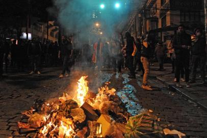 Supporters of the Comunidad Ciudadana opposition party stand behind a bonfire during clashes with police as they try to reach the Electoral Supreme Tribunal after knowing the results of general elections in La Paz, on October 24, 2019. - Bolivian President Evo Morales declared victory Thursday in elections whose disputed results have triggered riots, a general strike and opposition charges that he is trying to steal the election to secure a fourth straight term. (Photo by JORGE BERNAL / AFP)