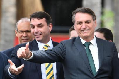 Brazilian President Jair Bolsonaro (R) gestures next to his son, senator Flavio Bolsonaro, during the launch of his new party, the Alliance for Brazil, at a hotel in Brasilia on November 20, 2019. - Bolsonaro left the Social Liberal Party after a disagreement with the party president Luciano Bivar. (Photo by EVARISTO SA / AFP)