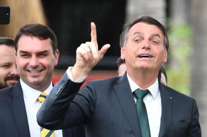 Brazilian President Jair Bolsonaro (R) gestures next to his son, senator Flavio Bolsonaro, during the launch of his new party, the Alliance for Brazil, at a hotel in Brasilia on November 20, 2019. - Bolsonaro left the Social Liberal Party after a disagreement with the party president Luciano Bivar. (Photo by EVARISTO SA / AFP)