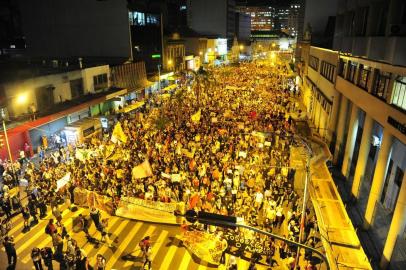 PORTO ALEGRE, RS, BRASIL, 01-04-2013: Manifestantes protestam contra o aumento da passagem de ônibus na Capital. Por volta das 18h30min, a manifestação mobilizada pelo facebook seguiu em caminhada pela Avenida Júlio de Castilhos, onde subiram no arco da estação do Trensurb. Em seguida, a multidão ocupou o terminal localizado no Centro Popular de Compras, pichou ônibus e impediu que os veículos partissem do local. (Foto: Ricardo Duarte/Agência RBS, GERAL)