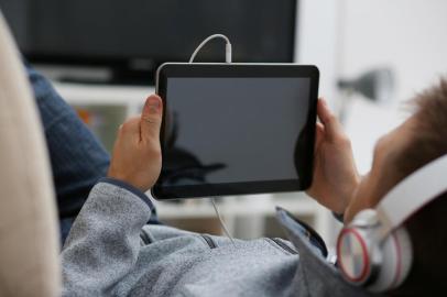 Male hand holds tablet in home setting whilePORTO ALEGRE, RS, BRASIL, Quatro em cada cinco adolescentes são sedentários. (Foto: ¿¿¿¿ ¿¿¿¿¿¿¿¿ / stock.adobe.com)Fonte: 303669977