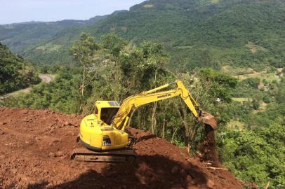 Retroescavaderia limpando terreno para trabalho de perfuração no alto de encosta junto à RS-122 em Farroupilha.