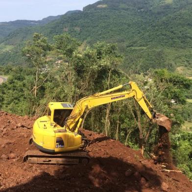 Retroescavaderia limpando terreno para trabalho de perfuração no alto de encosta junto à RS-122 em Farroupilha.