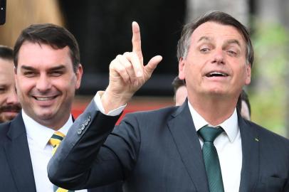 Brazilian President Jair Bolsonaro (R) gestures next to his son, senator Flavio Bolsonaro, during the launch of his new party, the Alliance for Brazil, at a hotel in Brasilia on November 20, 2019. - Bolsonaro left the Social Liberal Party after a disagreement with the party president Luciano Bivar. (Photo by EVARISTO SA / AFP)