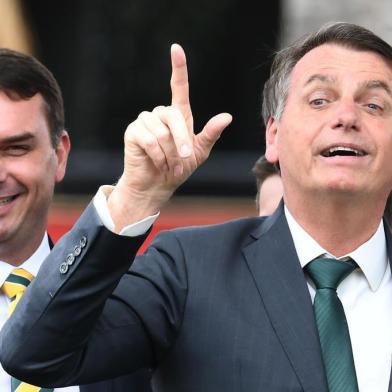 Brazilian President Jair Bolsonaro (R) gestures next to his son, senator Flavio Bolsonaro, during the launch of his new party, the Alliance for Brazil, at a hotel in Brasilia on November 20, 2019. - Bolsonaro left the Social Liberal Party after a disagreement with the party president Luciano Bivar. (Photo by EVARISTO SA / AFP)