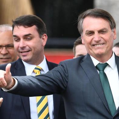 Brazilian President Jair Bolsonaro (R) gestures next to his son, senator Flavio Bolsonaro, during the launch of his new party, the Alliance for Brazil, at a hotel in Brasilia on November 20, 2019. - Bolsonaro left the Social Liberal Party after a disagreement with the party president Luciano Bivar. (Photo by EVARISTO SA / AFP)