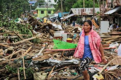 Residente passa por detritos de suas casas destruídas depois que o tufão Kammuri atingiu a cidade de Sorsogon. Foto: RAZVALE SAYAT / AFP