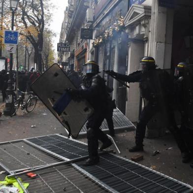 French anti-riot police officers charge during a demonstration against the pension overhauls, on Place de la Nation in Paris, on December 5, 2019, as part of a national general strike. - Trains cancelled, schools closed: France scrambled to make contingency plans on for a huge strike against pension overhauls that poses one of the biggest challenges yet to French Presidents sweeping reform drive. (Photo by Alain JOCARD / AFP)<!-- NICAID(14349598) -->