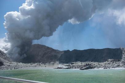 This handout photograph courtesy of Michael Schade shows the volcano on New Zealands White Island spewing steam and ash minutes following an eruption on December 9, 2019. - New Zealand police said at least one person was killed and more fatalities were likely, after an island volcano popular with tourists erupted on December 9 leaving dozens stranded. (Photo by Handout / Michael Schade / AFP) / RESTRICTED TO EDITORIAL USE - MANDATORY CREDIT AFP PHOTO / MICHAEL SCHADE - NO MARKETING NO ADVERTISING CAMPAIGNS - DISTRIBUTED AS A SERVICE TO CLIENTS == NO ARCHIVE<!-- NICAID(14354558) -->