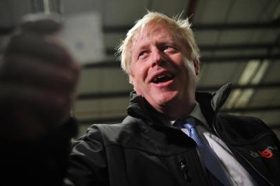  Britains Prime Minister and Conservative party leader Boris Johnson reacts after reading the joke found inside one of the crackers during a visit to IG Design Group, wrapping paper designer and producer in Hengoed, south Wales on December 11, 2019, the final day of campaigning for the general election. - Britain will go to the polls tomorrow to vote in a pre-Christmas general election. (Photo by Ben STANSALL / POOL / AFP)Editoria: POLLocal: HengoedIndexador: BEN STANSALLSecao: electionFonte: POOLFotógrafo: STF