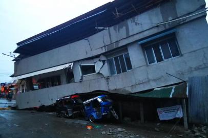  Residents look at a destroyed house with a vehicle squeezed underneath after a 6.8- magnitude earthquake in the town of Padada in Davao del Sur province on the island of southern Mindanao. - A powerful earthquake hit the southern Philippine island of Mindanao on December 15, killing a child and damaging buildings in an area still recovering from a string of deadly quakes in October. (Photo by FERDINANDH CABRERA / AFP)Editoria: DISLocal: PadadaIndexador: FERDINANDH CABRERASecao: earthquakeFonte: AFPFotógrafo: STR<!-- NICAID(14359523) -->