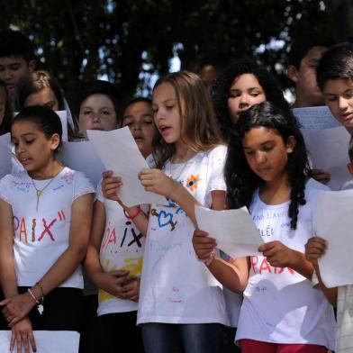  CAXIAS DO SUL, RS, BRASIL, 11/12/2019 - Escola Nova Esperança, no loteamento Vila Amélia, em Caxias do Sul, motiva alunos a cantar em francês para transmitir mensagem de paz. Projeto incluiu também a inscrição dos nomes de pessoas que os estudantes e a comunidade escolar amam num muro do ginásio. NA FOTO: as turmas 52A e 52B das professoras Liciane Troian e Merielen Camara cantando a canção francesa On Ecrit Sur Les Murs. (Marcelo Casagrande/Agência RBS)