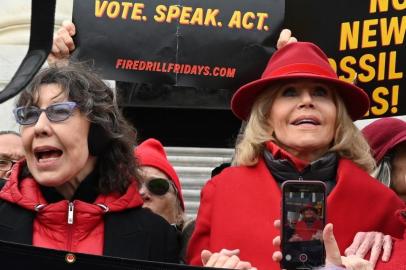 Actresses and activists Lily Tomlin (L) and Jane Fonda hold hands as they lead a climate protest on the steps of the US Capitol in Washington, DC on December 27, 2019. - The rally marked the 12th consecutive Friday that Jane Fonda has led protests in Washington, DC. The protests call for an end to new fossil fuel exploration while this weeks demonstration focused on the impact of climate change on the worlds forests. (Photo by Eva HAMBACH / AFP)<!-- NICAID(14372486) -->