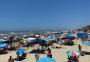 Com céu azul e praia lotada, banhistas passam o dia na beira-mar em Capão da Canoa