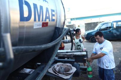  PORTO ALEGRE, RS, BRASIL, 30/12/2019: Falta de água na Lomba do Pinheiro. Na foto: Adriano Machado, vendedor de salgados, do Loteamento Santo Antônio, enchendo baldes com água do caminhão-pipaIndexador: ISADORA NEUMANN