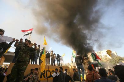  Membros do gripo pró Irã al-Shaabi e protestantes em represália ao bombardeiro dos EUA, com ataque à embaixada dos EUA no IraqueMembers of the Iraqi pro-Iranian Hashed al-Shaabi group and protesters set ablaze a sentry box in front of the US embassy building in the capital Baghdad to protest against the weekend's air strikes by US planes on several bases belonging to the Hezbollah brigades near Al-Qaim, an Iraqi district bordering Syria, on December 31, 2019. Several thousand Iraqi protesters attacked the US embassy in Baghdad on today, breaching its outer wall and chanting "Death to America!" in anger over weekend air strikes that killed pro-Iran fighters.Editoria: POLLocal: BaghdadIndexador: AHMAD AL-RUBAYESecao: demonstrationFonte: AFPFotógrafo: STF<!-- NICAID(14374423) -->