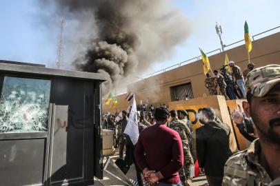  Membros do gripo pró Irã al-Shaabi e protestantes em represália ao bombardeiro dos EUA, com ataque à embaixada dos EUA no IraqueMembers of the Iraqi pro-Iranian Hashed al-Shaabi group and protesters set ablaze a sentry box in front of the US embassy building in the capital Baghdad to protest against the weekends air strikes by US planes on several bases belonging to the Hezbollah brigades near Al-Qaim, an Iraqi district bordering Syria, on December 31, 2019. Several thousand Iraqi protesters attacked the US embassy in Baghdad on today, breaching its outer wall and chanting Death to America! in anger over weekend air strikes that killed pro-Iran fighters.Editoria: POLLocal: BaghdadIndexador: AHMAD AL-RUBAYESecao: demonstrationFonte: AFPFotógrafo: STF<!-- NICAID(14374424) -->