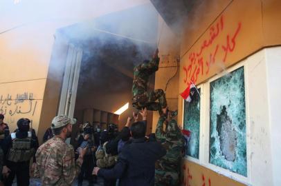  Members the Hashed al-Shaabi, a mostly Shiite network of local armed groups trained and armed by powerful neighbour Iran, smash the bullet-proof glass of the US embassys windows in Baghdad with blocks of cement after breaching the outer wall of the diplomatic mission on December 31, 2019 to vent their anger over weekend air strikes that killed pro-Iran fighters in western Iraq. - It was the first time in years protesters have been able to reach the US embassy in the Iraqi capital, which is sheltered behind a series of checkpoints in the high-security Green Zone. (Photo by AHMAD AL-RUBAYE / AFP)Editoria: WARLocal: BaghdadIndexador: AHMAD AL-RUBAYESecao: demonstrationFonte: AFPFotógrafo: STF<!-- NICAID(14374584) -->