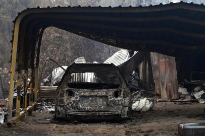  A burnt vehicle is seen inside a gutted house after an overnight bushfire in Quaama in Australias New South Wales state on January 6, 2020. - Reserve troops were deployed to fire-ravaged regions across three Australian states on January 6 after a torrid weekend that turned swathes of land into smouldering, blackened hellscapes. (Photo by SAEED KHAN / AFP)Editoria: DISLocal: QuaamaIndexador: SAEED KHANSecao: fireFonte: AFPFotógrafo: STF<!-- NICAID(14377511) -->