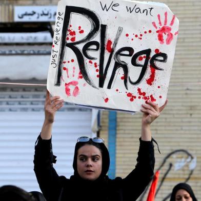  An Iranian mourner holds a placard during the final stage of funeral processions for slain top general Qasem Soleimani, in his hometown Kerman on January 7, 2020. - Soleimani was killed outside Baghdad airport on January 3 in a drone strike ordered by US President Donald Trump, ratcheting up tensions with arch-enemy Iran which has vowed severe revenge. The assassination of the 62-year-old heightened international concern about a new war in the volatile, oil-rich Middle East and rattled financial markets. (Photo by ATTA KENARE / AFP)Editoria: WARLocal: KermanIndexador: ATTA KENARESecao: civil unrestFonte: AFPFotógrafo: STF<!-- NICAID(14379250) -->