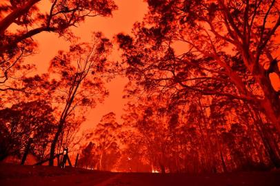 The afternoon sky glows red from bushfires in the area around the town of Nowra in the Australian state of New South Wales on December 31, 2019. - Thousands of holidaymakers and locals were forced to flee to beaches in fire-ravaged southeast Australia on December 31, as blazes ripped through popular tourist areas leaving no escape by land. (Photo by SAEED KHAN / AFP)<!-- NICAID(14376217) -->