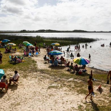  CIDREIRA, RS, BRASIL, 04-01-2020 - Evandro Ronise, 34 anos, ao lado da esposa, Caroline de Oliveira (D), 26, aproveita dia de calor com familiares na Lagoa Fortaleza, em Cidreira. Lagoas, cachoeiras e dunas perto da praia sao opcoes de passeio para quem procura uma alternativa ao mar. (Foto: Mateus Bruxel / Agencia RBS)Indexador: Mateus Bruxel<!-- NICAID(14382380) -->